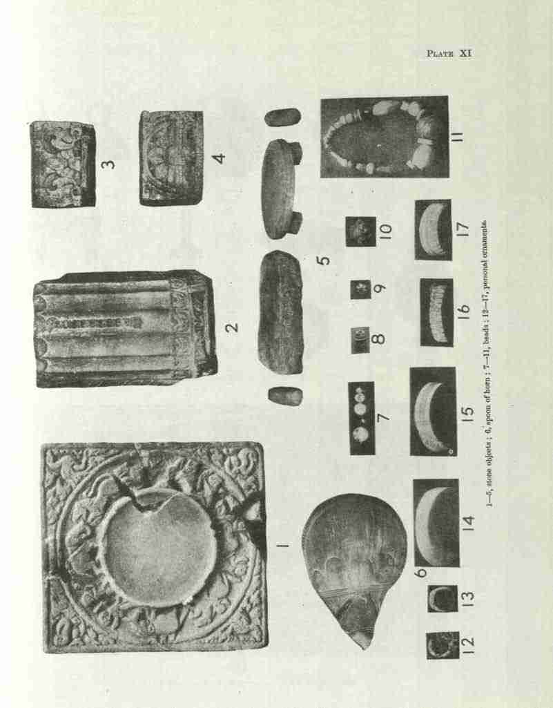 A plate of small finds from Agroha: a heavily decorated stone disc, terracotta plaques with figural decoration, beads and ornaments laid out for photography